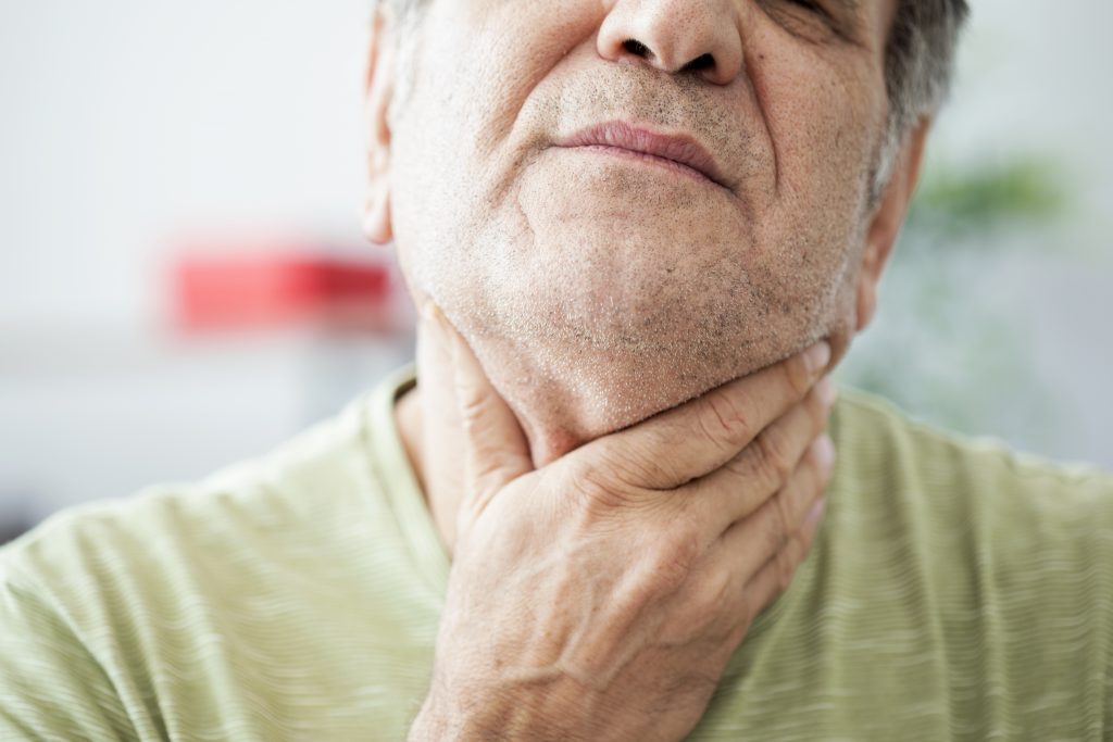Old man feeling painful in the throat