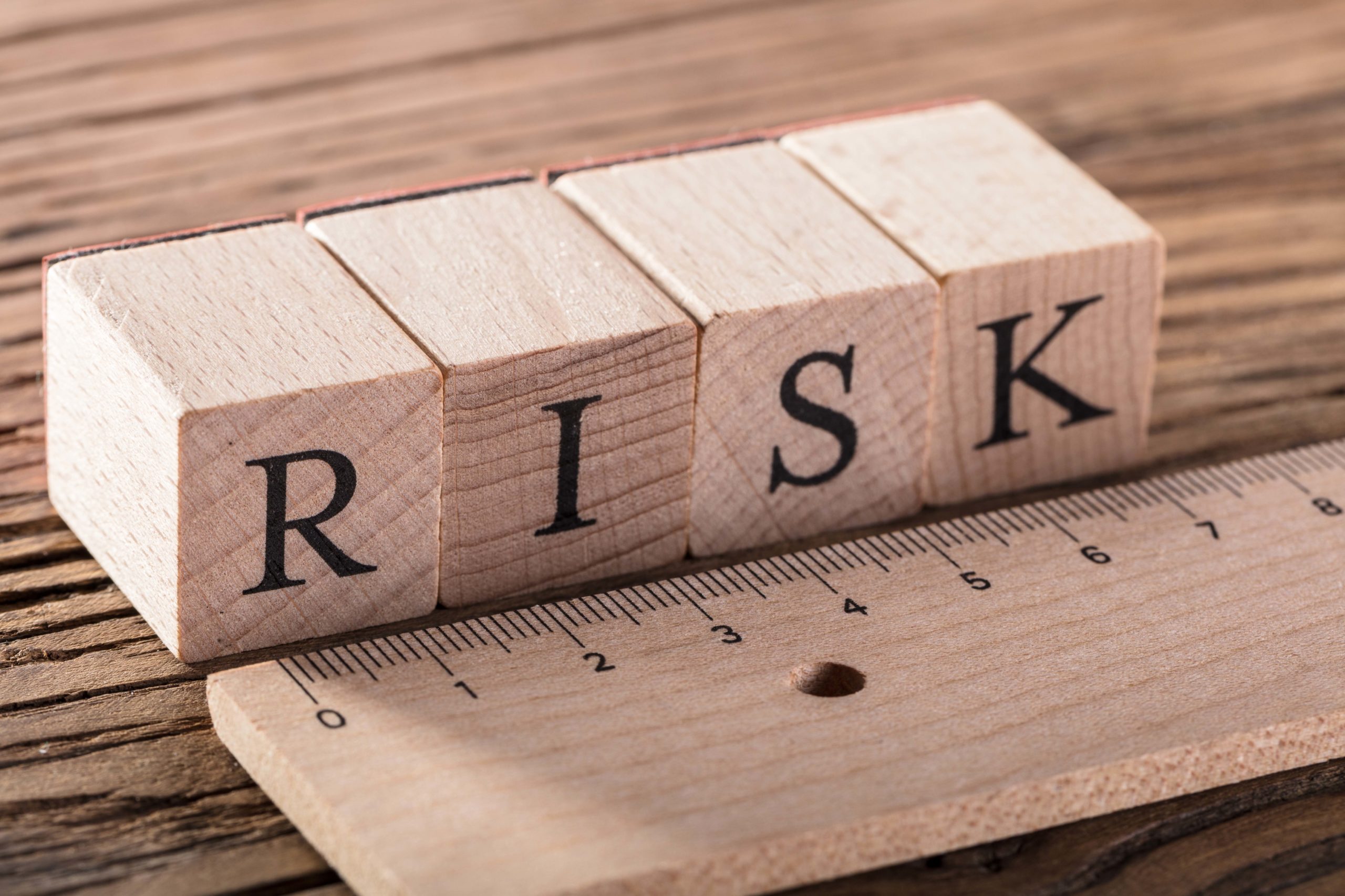 Risk Word On Blocks Arranged Behind The Ruler On Wooden Table