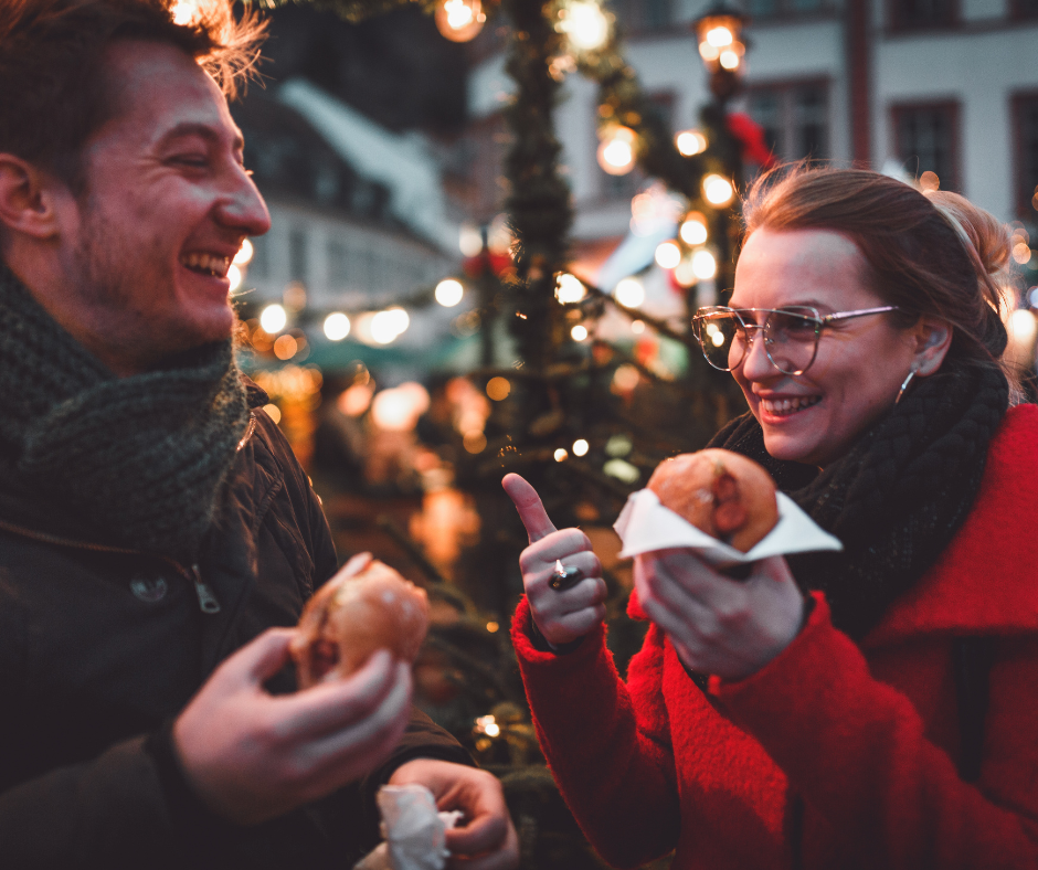 Young couple at Christmas market with snack in their hand