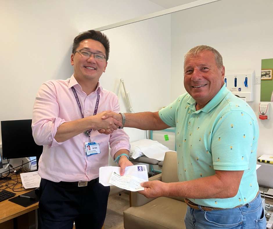 Peter Papanastasiou handing over a cheque to his consultant at the Royal Marsden for Oracle Cancer Trust