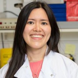 Charleen Chan smiling into camera with lab coat on