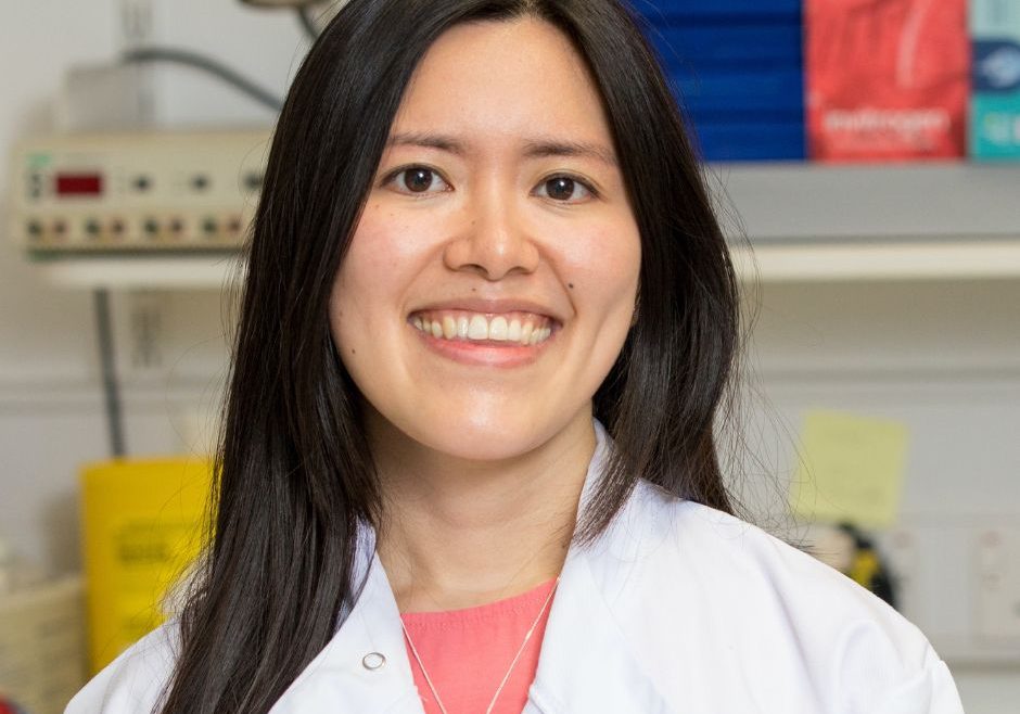 Charleen Chan smiling into camera with lab coat on